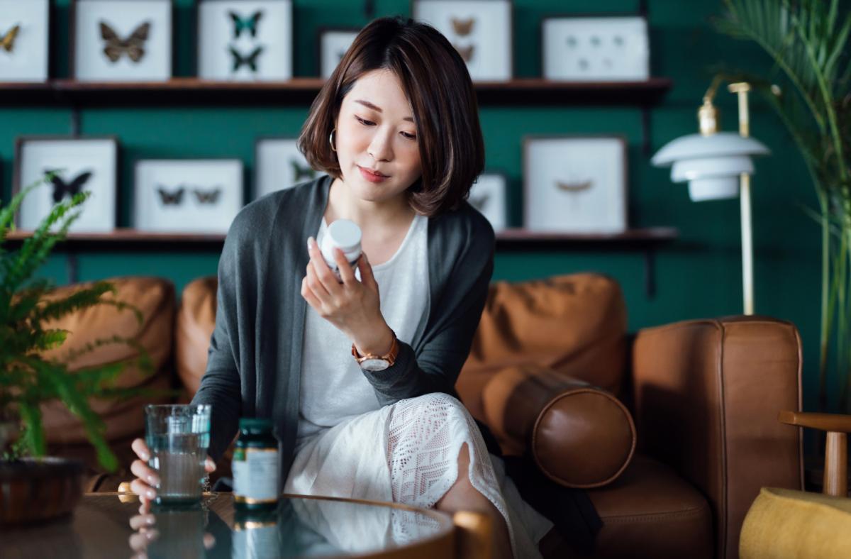 Woman reading the back of a vitamin bottle